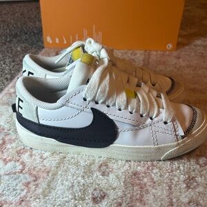 Nike Low-Top Sneakers — White with Black Swoosh and Yellow Tongue Tab